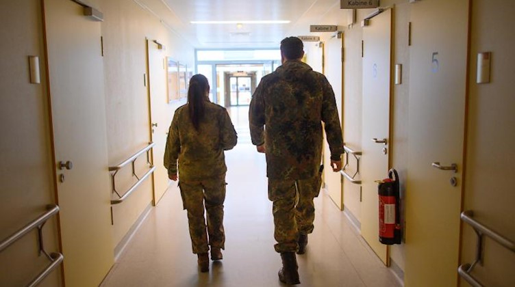 Stabsunteroffizierin und Stabsfeldwebel laufen durch eine Klinik. Foto: Robert Michael/dpa-Zentralbild/dpa