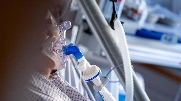Eine an Covid-19 erkrankte Patientin wird auf einer Intensivstation mit einer Maske beatmet. Foto: Jens Büttner/dpa-Zentralbild/dpa/Symbolbild