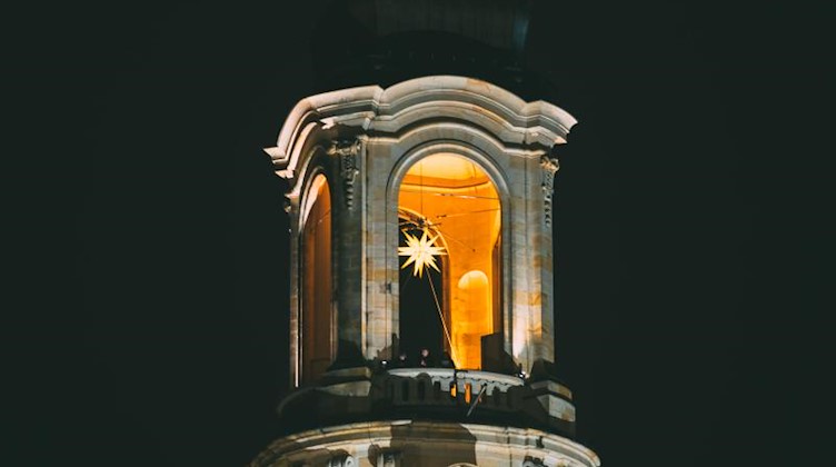 Ein Adventsstern brennt in der Kuppel der Frauenkirche in Dresden. Foto: Oliver Killig/dpa/Archivbild