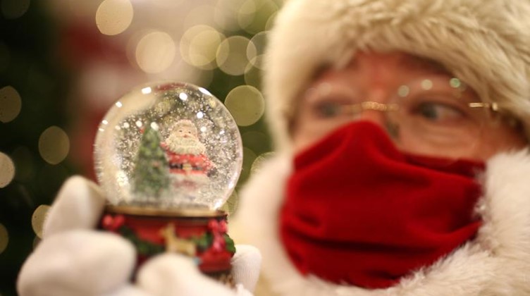 Ein als Weihnachtsmann verkleideter Mann hält eine Schneekugel in den Händen. Foto: Yui Mok/PA Wire/dpa/Symbolbild