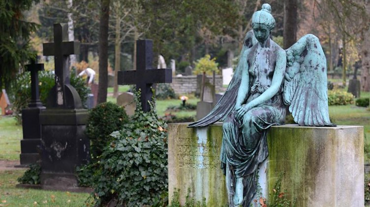 Ein Grabstelle mit einem sitzenden Engel auf dem 1875 angelegten Johannisfriedhof. Foto: Matthias Hiekel/dpa-Zentralbild/dpa/Archivbild