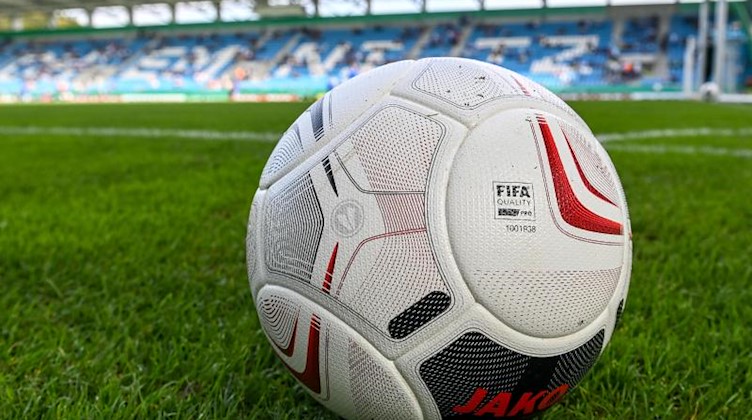 Ein Fußball liegt auf einer Rasenfläche. Foto: Hendrik Schmidt/dpa-Zentralbild/ZB/Symbolbild