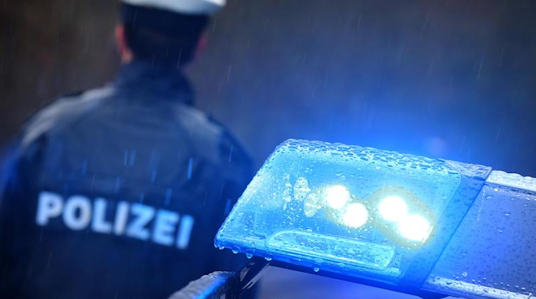Ein Polizist steht vor einem Streifenwagen. Foto: Karl-Josef Hildenbrand/dpa/Symbolbild