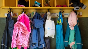 Jacken und Taschen hängen im Eingangsbereich eines Kindergartens. Foto: Monika Skolimowska/dpa-Zentralbild/dpa/Symbolbild