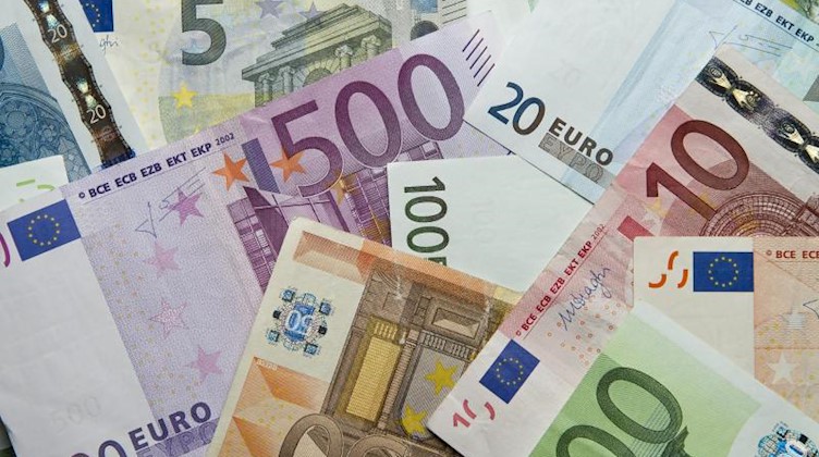 Zahlreiche Euro-Banknoten liegen auf einem Haufen. Foto: Daniel Reinhardt/dpa/Archivbild