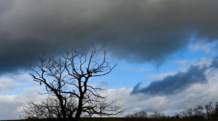 Dunkle Wolken ziehen über eine Landschaft. Foto: Patrick Pleul/dpa-Zentralbild/ZB/Symbolbild