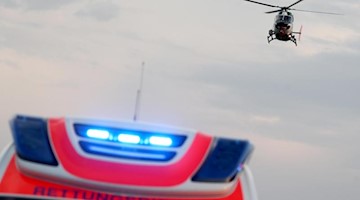 Ein Hubschrauber fliegt über einem Rettungswagen zu einem Unfallort. Foto: Jan Woitas/dpa-Zentralbild/dpa/Symbolbild