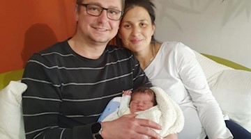 Vater Guido und Mutter Ayleen halten ihr neugeborenes Mädchen, das Sachsens erstes Neujahrsbaby ist. Foto: Privat/-/dpa