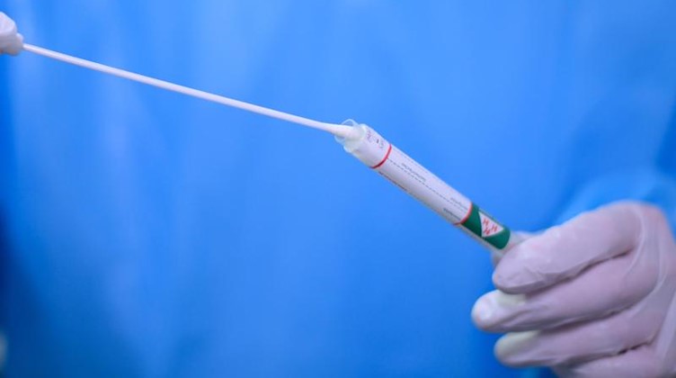 Ein Arzt hält einen Coronavirus-Test in den Händen. Foto: Robert Michael/dpa-Zentralbild/dpa/Symbolbild