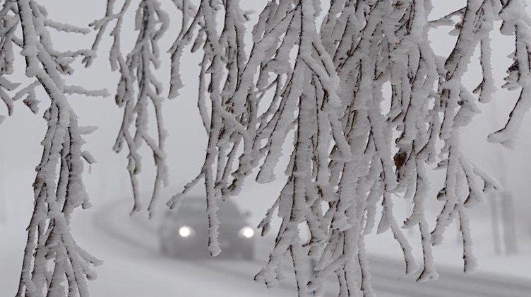 Ein Auto fährt durch die verschneite Landschaft. Foto: Robert Michael/dpa-Zentralbild/dpa
