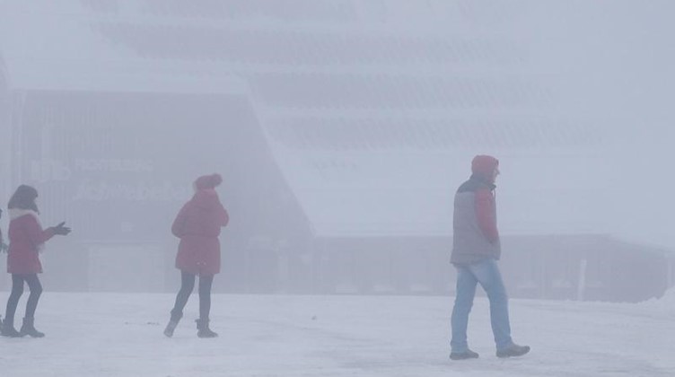 Menschen gehen bei Nebel auf dem Fichtelberg spazieren. Foto: Sebastian Willnow/dpa-Zentralbild/dpa/Symbolbild