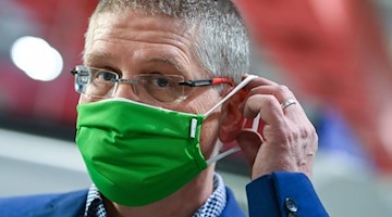 Björn-Olaf Dröge, Geschäftsführer des Textilveredlers pro4tex, setzt sich eine Mehrweg-Maske auf. Foto: Hendrik Schmidt/dpa-Zentralbild/dpa