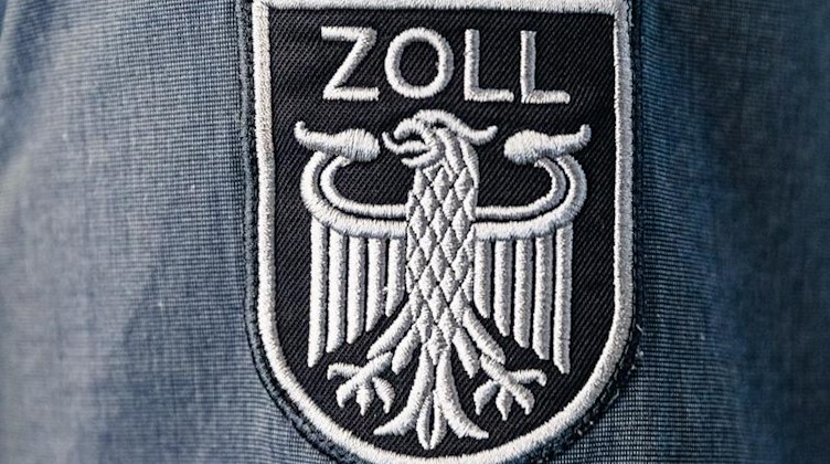 Das Wappen des Zolls ohne die Bundesfarben ist auf der Arbeitsuniform eines Beamten angebracht. Foto: Markus Scholz/dpa/Archiv