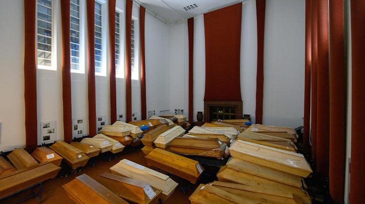 Särge stehen vor der Einäscherung im Andachtsraum im Krematorium. Foto: Robert Michael/dpa-Zentralbild/dpa