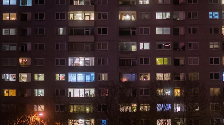 Das Licht ist abends in einigen Wohnungen eines Mehrfamilienhauses eingeschaltet. Foto: Julian Stratenschulte/dpa/Symbolbild