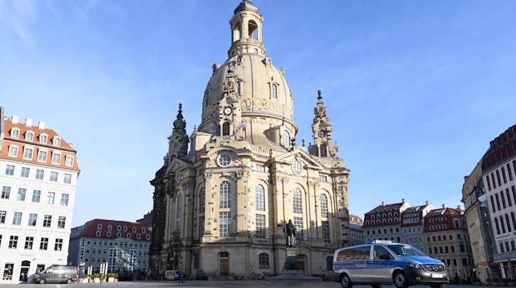Ein Polizeiauto steht vor der Frauenkirche auf dem Neumarkt. Foto: Sebastian Kahnert/dpa-Zentralbild/dpa
