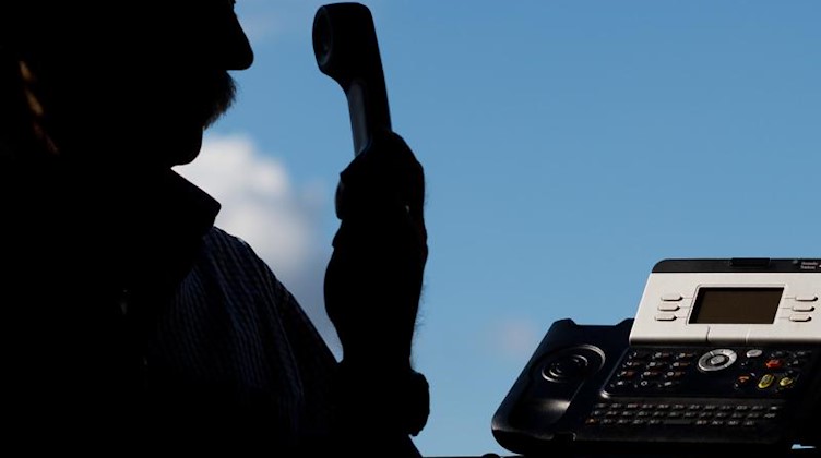 Ein Mann hält einen Telefonhörer in der Hand. Foto: Julian Stratenschulte/dpa/Symbolbild