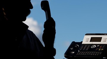 Ein Mann hält einen Telefonhörer in der Hand. Foto: Julian Stratenschulte/dpa/Symbolbild