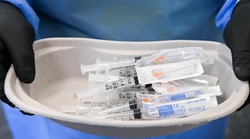 Eine Arzthelferin hält fertig präparierte Spritzen für die Impfungen gegen das Coronavirus in ihren Händen. Foto: Hendrik Schmidt/dpa-Zentralbild/dpa