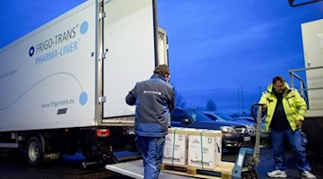 Fahrer eines Kühllastwagens entladen in einem Logistikzentrum Kisten mit Impfdosen. Foto: Klaus-Dietmar Gabbert/dpa-Zentralbild/dpa/Archivbild