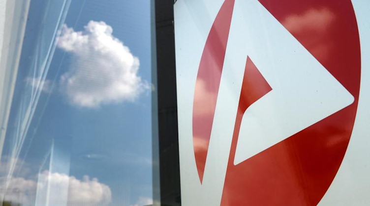Das Logo vom Jobcenter spiegelt sich am Eingang. Foto: Jens Kalaene/zb/dpa/Symbolbild