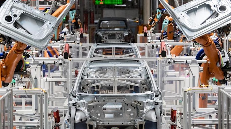 Im Karosseriebau des Volkswagen-Werkes in Sachsen montieren Roboter die Türen des VW ID.3. Foto: Hendrik Schmidt/dpa-Zentralbild/dpa/Archivbild