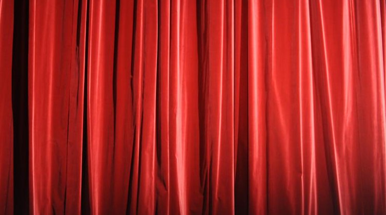 Der rote Vorhang eines Theaters ist zu sehen. Foto: Marcus Brandt/dpa/Symbolbild
