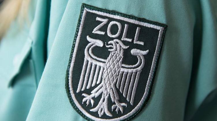Das Zollwappen auf dem Hemd einer Zollbeamtin. Foto: Sebastian Kahnert/dpa-Zentralbild/dpa