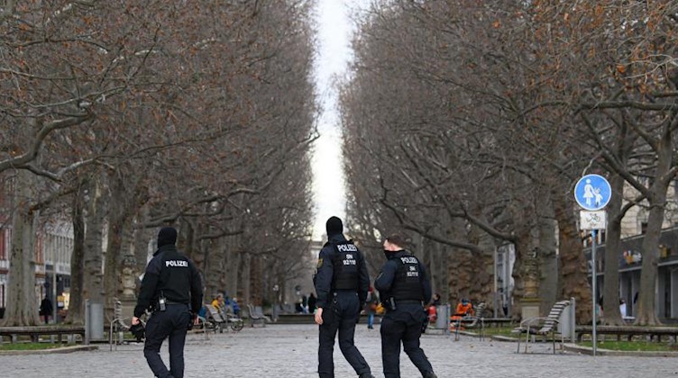 Polizisten laufen über die Hauptstraße in Dresden, um die Einhaltung der Corona-Schutzverordnung zu kontrollieren. Foto: Robert Michael/dpa-Zentralbild/dpa/Archivbild
