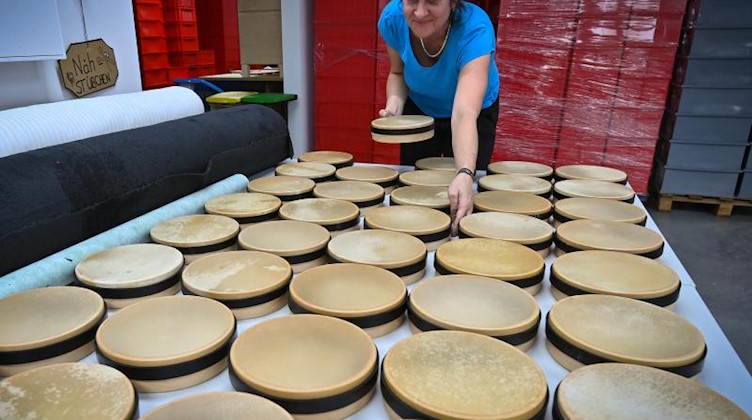 Eine Mitarbeiterin fertigt Tamburine in der Produktion der Rohema Percussion in Markneukirchen. Foto: Hendrik Schmidt/dpa-Zentralbild/ZB/Archivbild