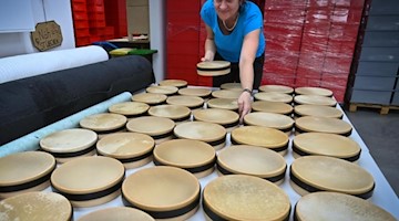 Eine Mitarbeiterin fertigt Tamburine in der Produktion der Rohema Percussion in Markneukirchen. Foto: Hendrik Schmidt/dpa-Zentralbild/ZB/Archivbild
