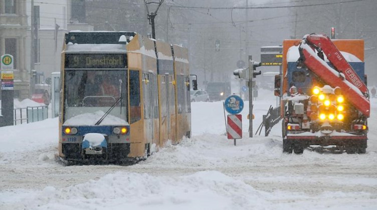 Eine Straßenbahn steht auf verschneiten Gleisen in der Leipziger Innenstadt. Foto: Sebastian Willnow/dpa-Zentralbild/dpa