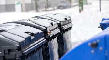 Müllcontainer sind von Schnee bedeckt. Foto: Jonas Walzberg/dpa/Symbolbild