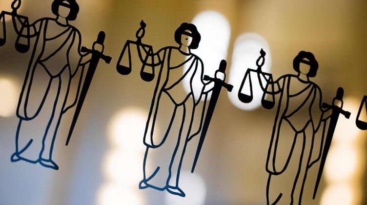 Justitia-Abbildungen sind an einer Scheibe am Eingang zum Oberlandesgericht zu sehen. Foto: Rolf Vennenbernd/dpa/Archivbild