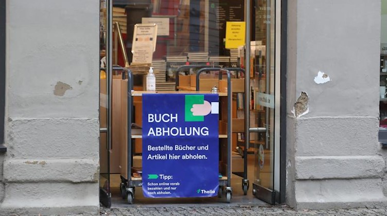 «Buchabholung» steht auf einer Tafel an einer Buchhandlung. Foto: Bodo Schackow/dpa-Zentralbild/dpa/Sachsen