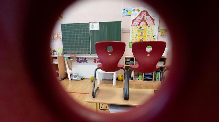 Stühle stehen in einem Klassenzimmer einer ersten Klasse. Foto: Marijan Murat/dpa