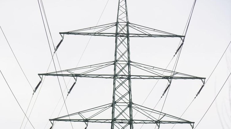Ein Strommast ragt in den Himmel. Foto: Frank Rumpenhorst/dpa/Symbolbild