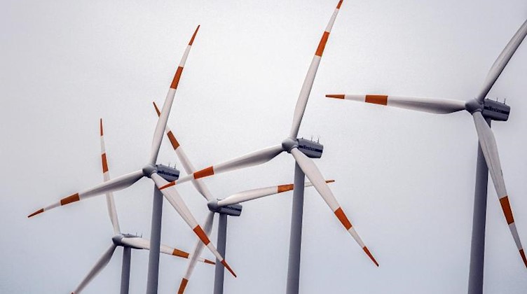 Windräder drehen sich vor dem grauen Himmel. Foto: Federico Gambarini/dpa/Symbolbild
