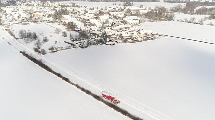 Eine Schneeschleuder der Deutschen Bahn befreit eine Zugstrecke. Foto: Julian Stratenschulte/dpa
