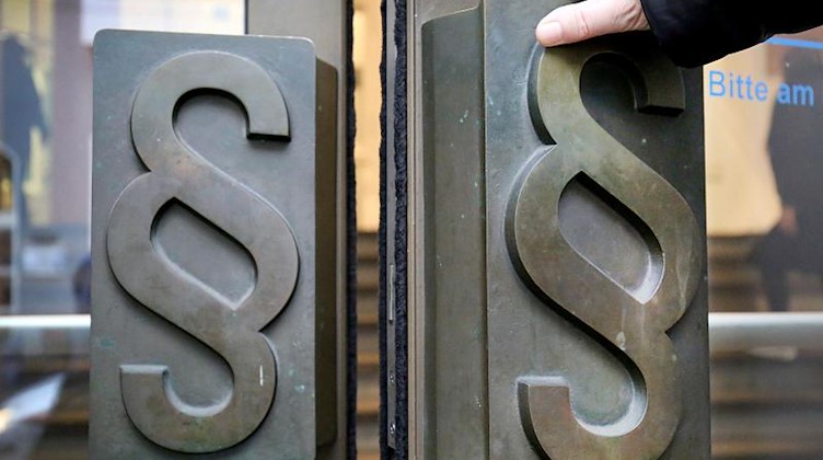 Paragrafen-Symbole sind an Türgriffen am Eingang zum Landgericht angebracht. Foto: Oliver Berg/dpa/Symbolbild