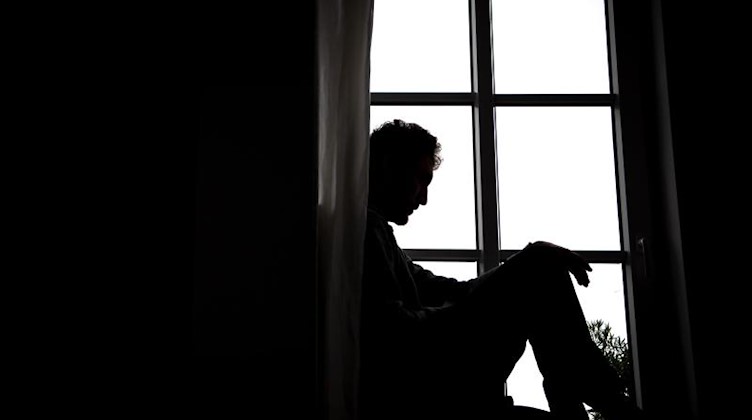 Ein Mann sitzt vor einem Fenster. Foto: Sina Schuldt/dpa/Archivbild