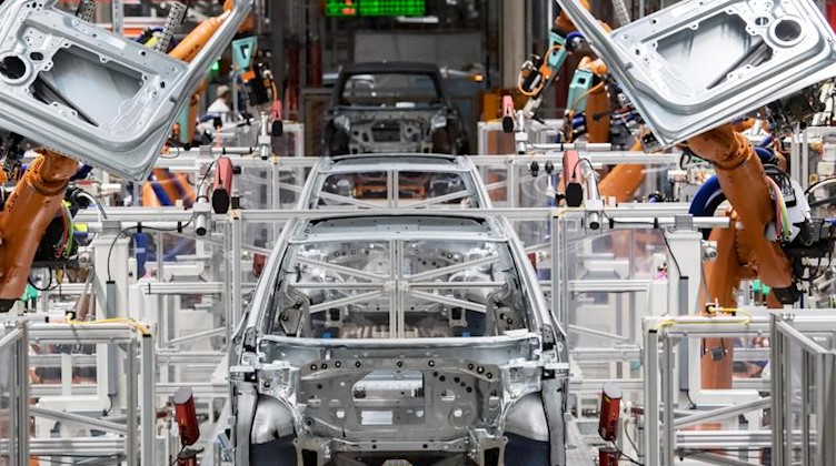 Im Karosseriebau des Volkswagen-Werkes in Sachsen montieren Roboter die Türen des VW ID.3. Foto: Hendrik Schmidt/dpa-Zentralbild/dpa