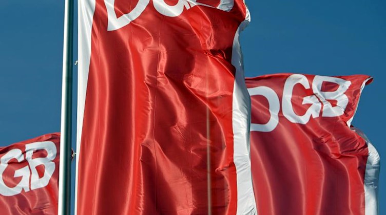 Fahnen des Deutschen Gewerkschaftsbunds (DGB) wehen vor blauem Himmel. Foto: Jan Woitas/dpa-Zentralbild/dpa/Archivbild