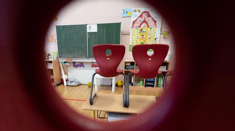 Stühle stehen in einem Klassenzimmer auf den Tischen. Foto: Marijan Murat/dpa