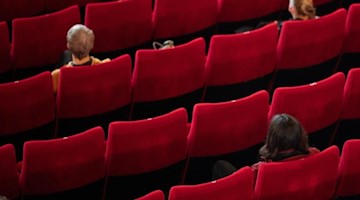Wenige Besucher sitzen in einem Kinosaal. Foto: Daniel Reinhardt/dpa/Symbolbild