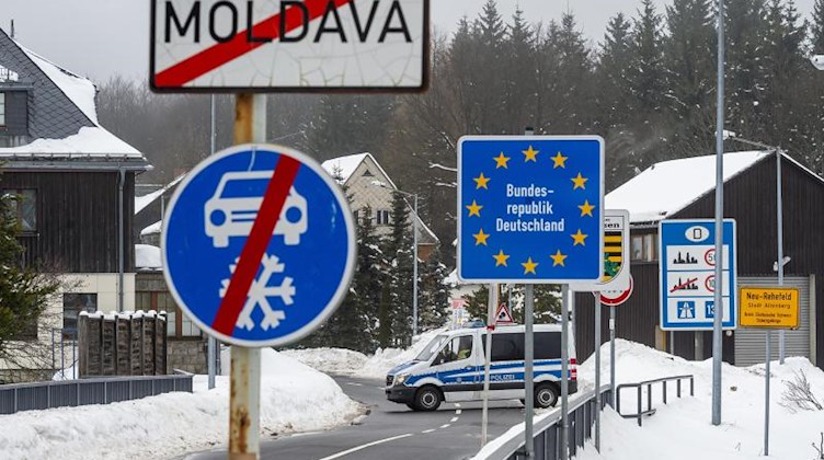 Deutsche Polizeibeamte blockieren den Grenzübergang Moldau/Neurehefeld im Erzgebirge mit einem Einsatzfahrzeug. Foto: Ondøej Hájek/CTK/dpa