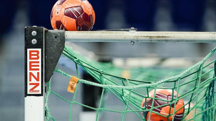 Spielbälle liegen im Netz eines Handball-Tors. Foto: Uwe Anspach/dpa/Symbolbild