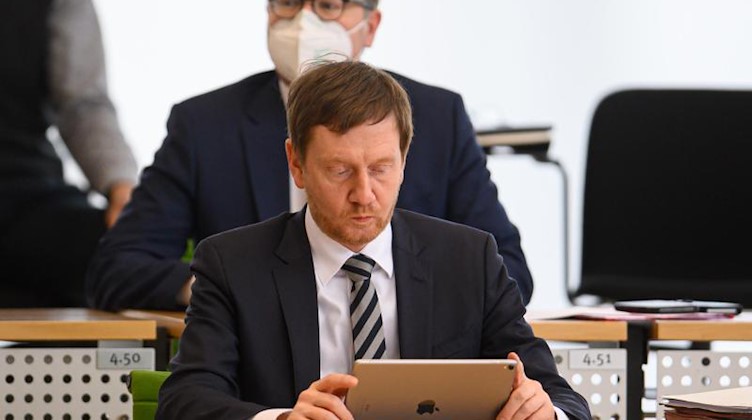 Michael Kretschmer (CDU) schaut auf sein Tablet. Foto: Robert Michael/dpa-Zentralbild/dpa/Archivbild