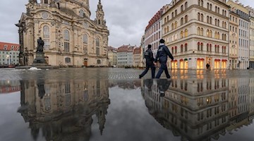 Zwei Mitarbeiter des Ordnungsamts gehen über den Dresdner Neumarkt. Foto: Robert Michael/dpa-Zentralbild/dpa/Archivbild