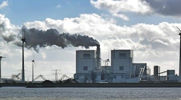 Ein Kohlekraftwerk inmitten von Windrädern. Foto: Holger Hollemann/dpa